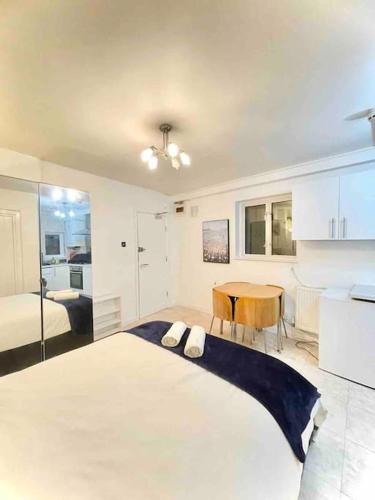 a bedroom with a large bed and a table at Great Studio flat in Central London in London