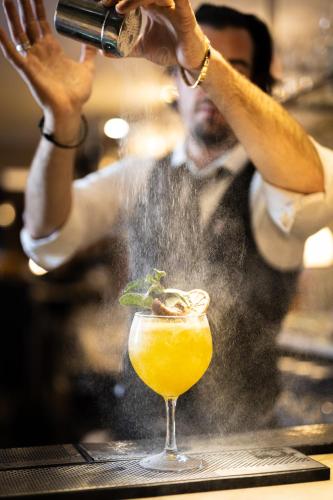 a man is making a drink in a glass at Harbour Hotel & Spa Brighton in Brighton & Hove