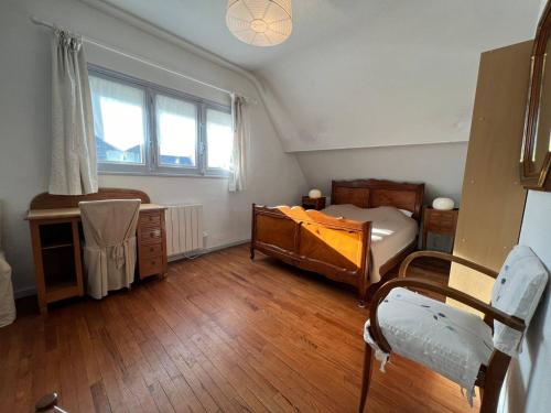 une chambre avec un lit, un bureau et une fenêtre dans l'établissement Maison cosy à Carnac - 3 chambres, terrasse, jardin, wifi - 150m de la plage - FR-1-377-34, à Carnac