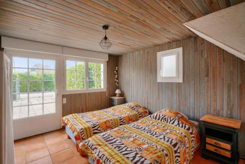 une chambre avec deux lits et une fenêtre dans l'établissement Maison 5 chambres avec accès direct à la plage, à Loctudy