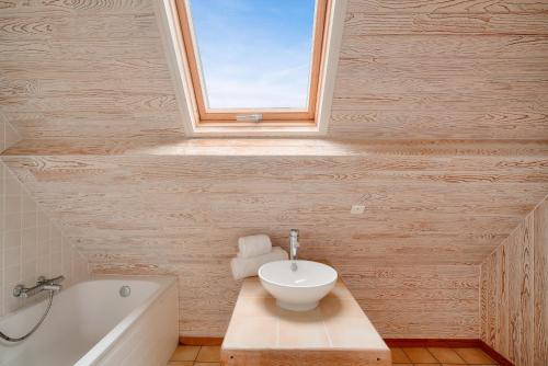 une salle de bain avec un lavabo et une baignoire dans l'établissement Maison 5 chambres avec accès direct à la plage, à Loctudy