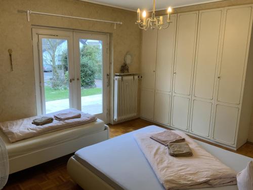 1 Schlafzimmer mit 2 Betten und einem großen Fenster in der Unterkunft The Green Park Nest Frankfurt in Friedrichsdorf