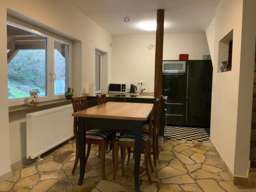 eine Küche mit einem Tisch und Stühlen sowie einem Kühlschrank in der Unterkunft The Green Park Nest Frankfurt in Friedrichsdorf