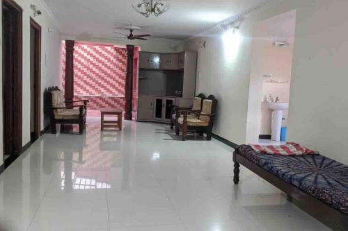 a living room with a couch and chairs in it at Cheerful home in Mysore