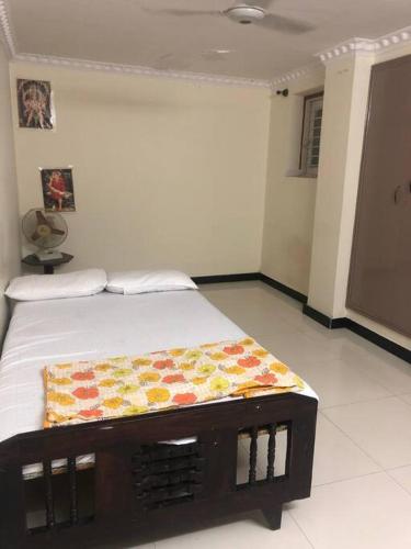 a bedroom with a bed with a blanket on it at Cheerful home in Mysore