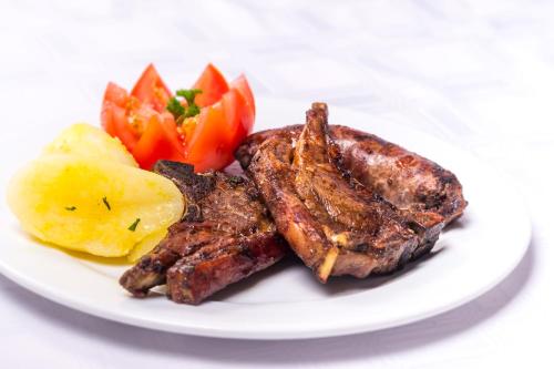 a plate of food with meat potatoes and vegetables at Bolivia Lodge in Polokwane