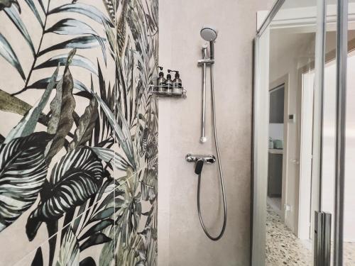 y baño con ducha y papel pintado tropical. en [Freshly renovated] 10 minutes from Arena, en Verona