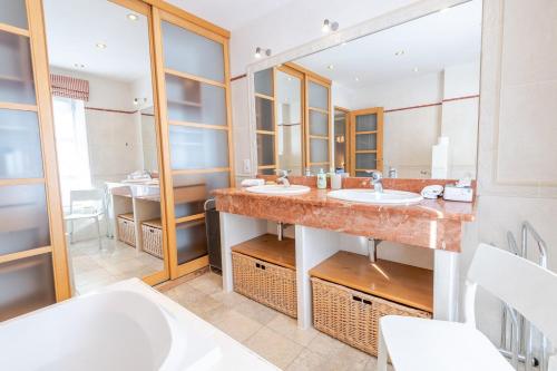 a bathroom with two sinks and a large mirror at Le Clos des Tilleuls - Gîte 10 personnes in Francueil