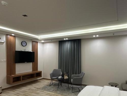 a room with two chairs and a flat screen tv at شركه فندق مون تري الفندقيه شركه من شخص واحد in Najran