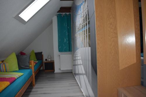 a attic room with a bed and a staircase at Marktstübchen an der schönen Loreley in Bornich