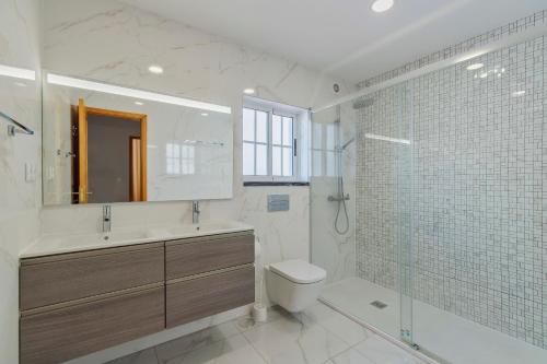 e bagno con lavandino, servizi igienici e doccia. di Casa Rosa a Quinta do Conde