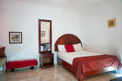 1 dormitorio con cama y espejo en Hotel Nuevo Amanecer en El Catey