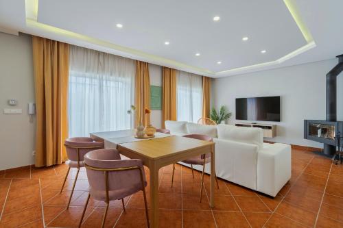 a living room with a white couch and a table at Casa Rosa in Quinta do Conde