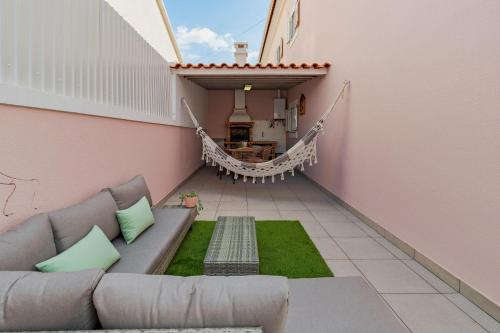 a living room with a couch and a hammock at Casa Rosa in Quinta do Conde
