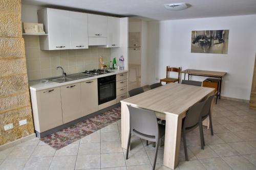 a kitchen and dining room with a table and chairs at Holiday Home Castle Salemi - Casa Vacanze in Salemi