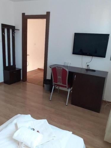 a bedroom with a desk with a computer and a chair at Pensiunea Otopeni in Otopeni