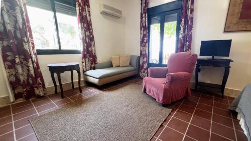 a living room with two chairs and a tv at Hotel Sindhura in Vejer de la Frontera