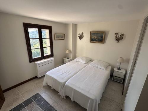 1 dormitorio con cama blanca y ventana en Villa Les Issambres, 5 pièces, 8 personnes - FR-1-768-73, en Roquebrune-sur-Argens