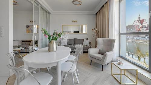 un comedor blanco con mesa y sillas en Lion Apartments - The Palace premium apartment with Old City & River View en Gdansk