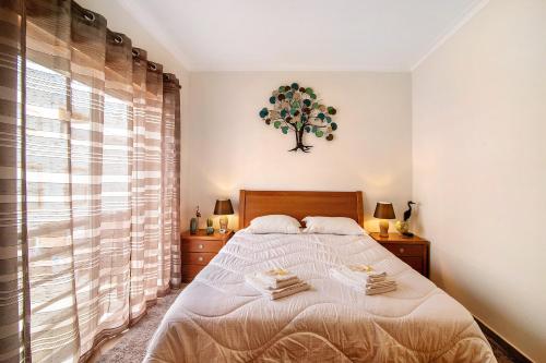 a bedroom with a bed and a tree on the wall at Quinta da Gomeira 60 in Tavira