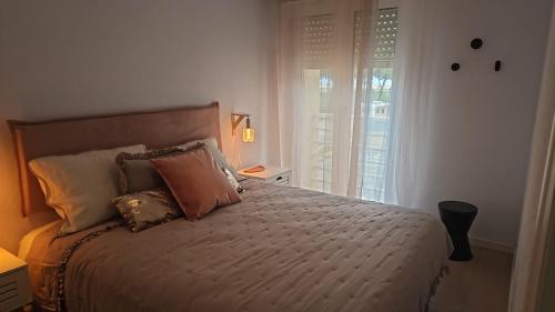 a bedroom with a bed with pillows and a window at Apartamentos Costa Norte in San Vicente de la Barquera