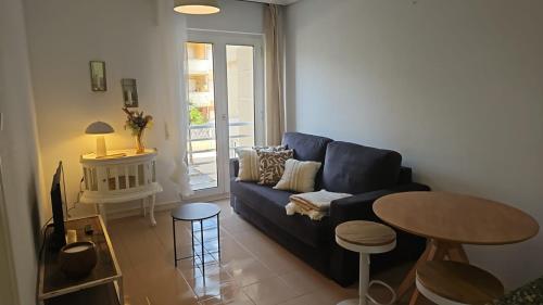a living room with a blue couch and a table at Apartamentos Costa Norte in San Vicente de la Barquera