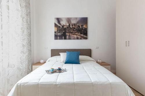 um quarto com uma cama branca e uma fotografia na parede em [Careggi/Mayer] comfortable apart em Florença