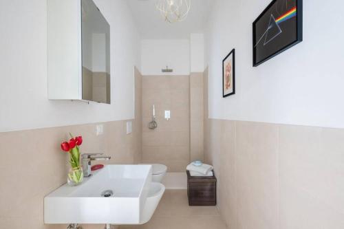 uma casa de banho branca com um lavatório e um WC em [Careggi/Mayer] comfortable apart em Florença