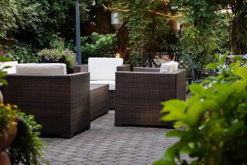 a group of wicker chairs and tables in a garden at Landhaus Alte Scheune in Frankfurt/Main