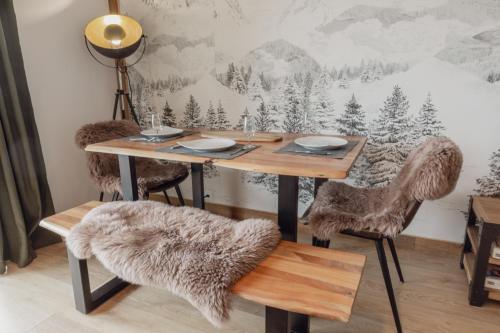 een eetkamer met een houten tafel en stoelen bij Magnifique appartement avec vue sur les montagnes in Crans-Montana