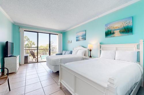 a blue bedroom with two beds and a balcony at Pirates Bay A210 in Fort Walton Beach