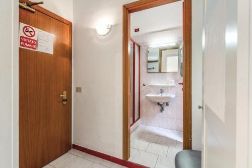 a bathroom with a sink and a mirror and a door at Hotel Altavilla 9 in Rome
