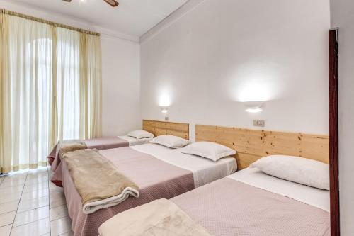 a group of three beds in a room at Hotel Altavilla 9 in Rome