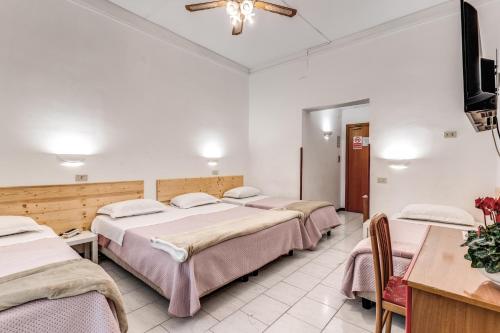 a hotel room with four beds and a flat screen tv at Hotel Altavilla 9 in Rome