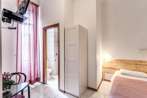 a bedroom with a bed and a table and a mirror at Hotel Altavilla 9 in Rome
