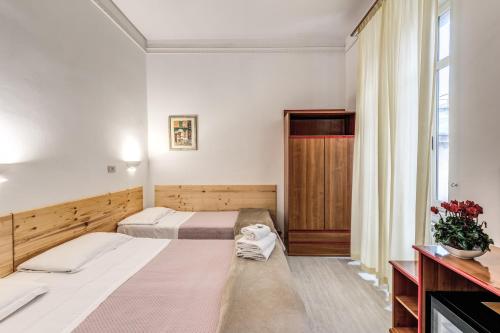 a hotel room with two beds and a window at Hotel Altavilla 9 in Rome