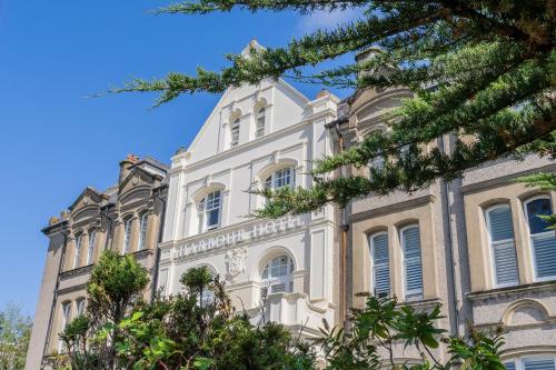 a large white building with trees in front of it at Harbour Hotel Padstow in Padstow