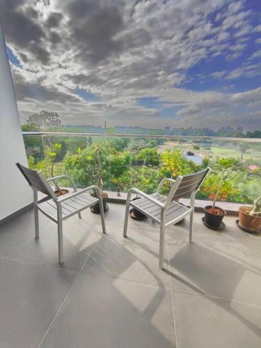 two white chairs sitting on a balcony with a view at Happy Home 3BHK Condo - Muttukadu ECR in Chennai