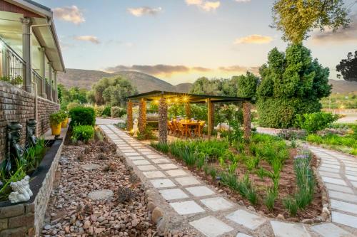 a garden with a gazebo and a patio at Die Fonteine Country Guesthouse and Glamping in Oudtshoorn