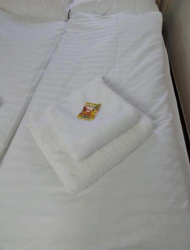 a white bed with a white towel on it at Strandperle - 100m zum Strand in Scharbeutz