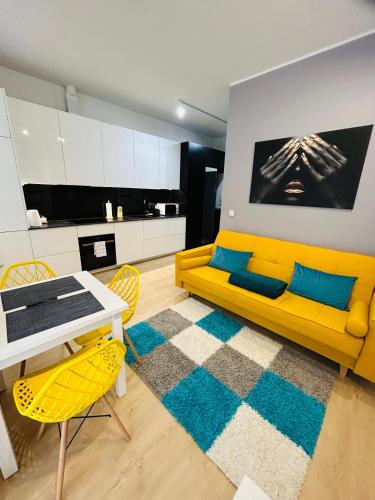 salon z żółtą kanapą i stołem w obiekcie Apartment Targowa L5 w mieście Lublin
