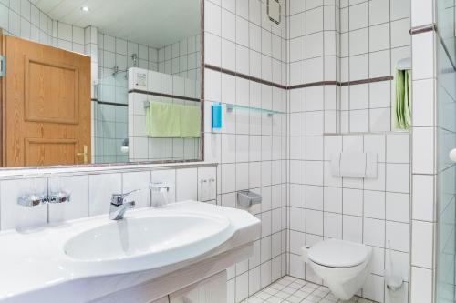 ein weißes Bad mit einem Waschbecken und einem WC in der Unterkunft Landhaus Alte Scheune in Frankfurt am Main