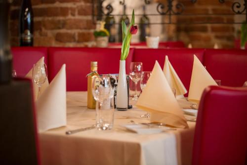a table with a bottle of wine and a flower on it at Landhaus Alte Scheune in Frankfurt/Main