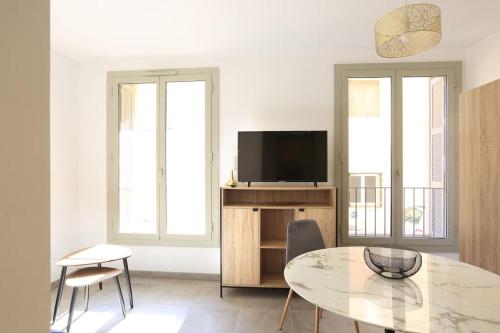 un salon avec une table et une télévision dans l'établissement Citadella confort moderne au centre de Calvi, à Calvi