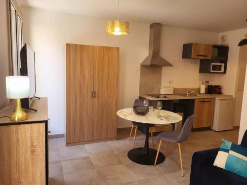 un salon avec une table et une cuisine dans l'établissement Citadella confort moderne au centre de Calvi, à Calvi