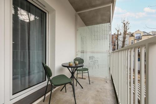 a balcony with a table and chairs and a window at Modern Studios in the Centre of Poznań by Noclegi Renters in Poznań