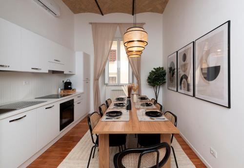 una cocina con una mesa de madera larga y sillas en colosseo flats and penthouse, en Roma