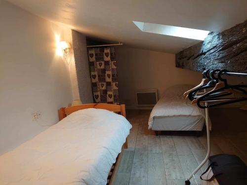 a bedroom with two beds in a small room at 5RBUT1 - Maison familiale sur deux niveaux en plein coeur du centre ville in Collioure