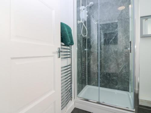 a shower with a glass door in a bathroom at Rockview Barn in Dufftown