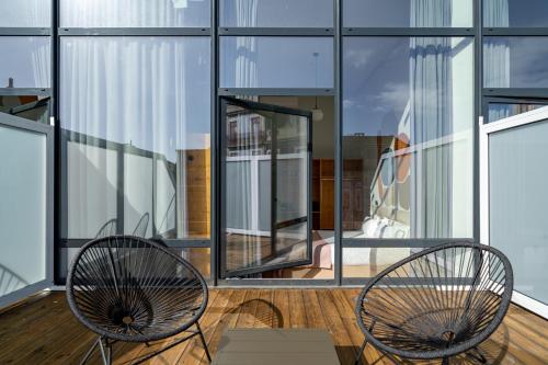 two chairs sitting on a balcony with windows at Limehome Porto Rua da Conceicao in Porto